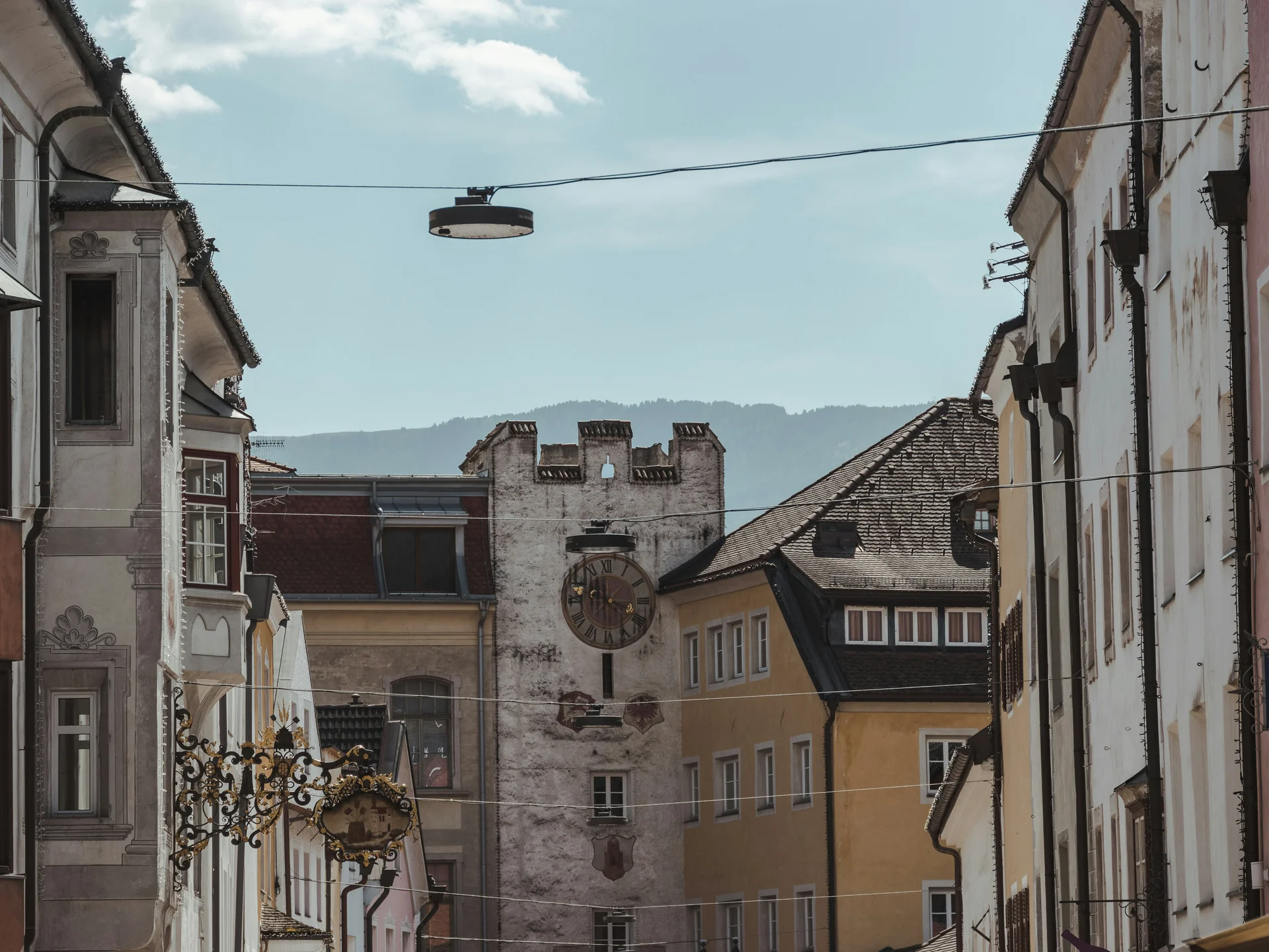Blick durch eine Altstadtgasse auf einen historischen Uhrturm