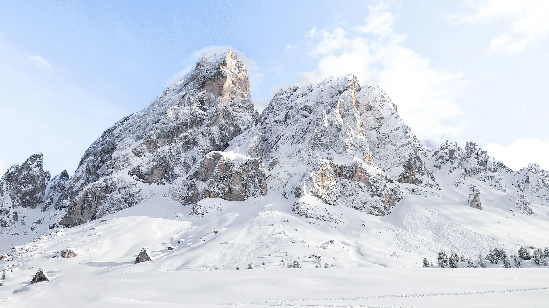 Verschneite, zerklüftete Berggipfel über einer weiten Schneelandschaft