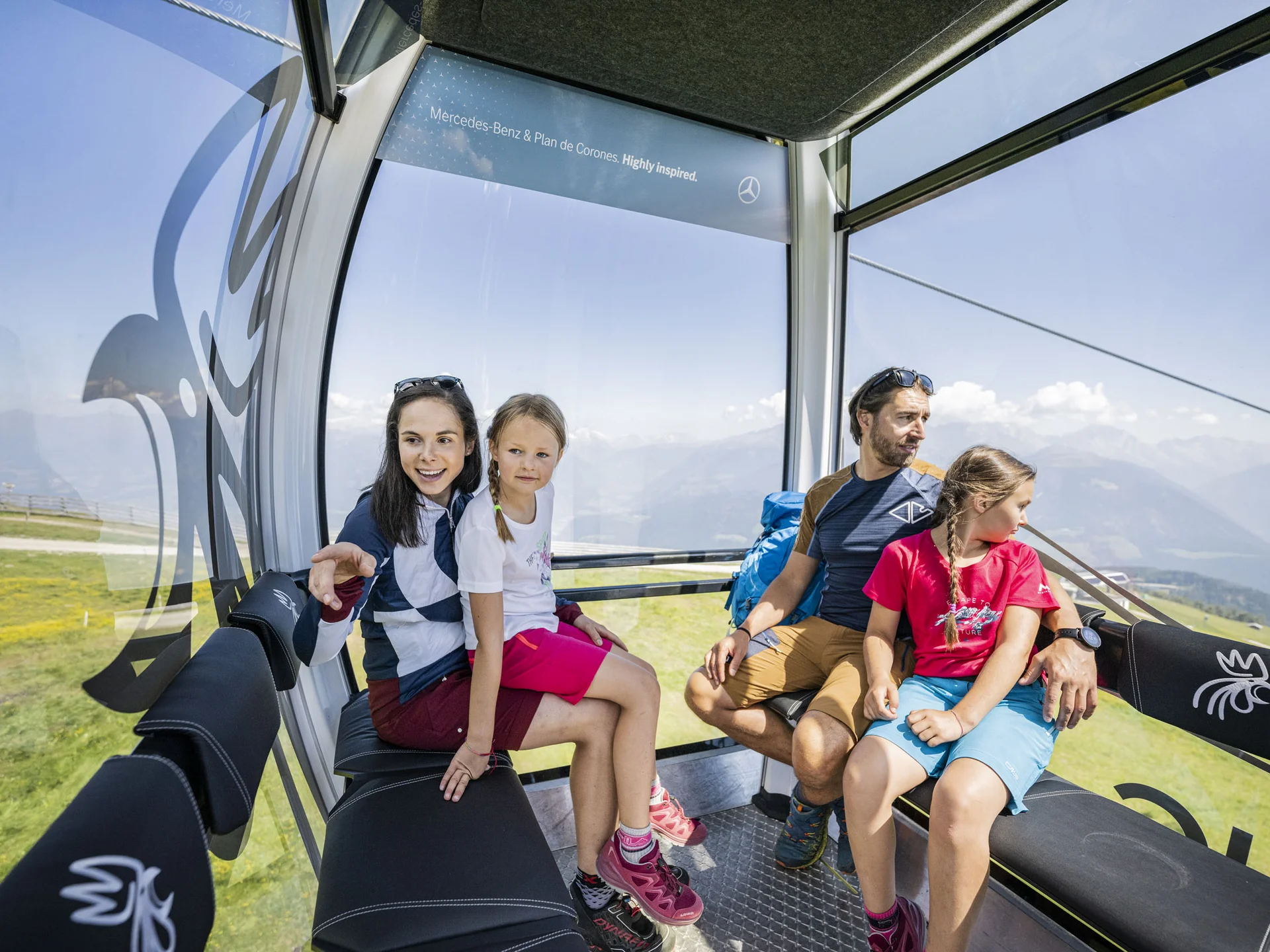 Ihr Chalet in den Dolomiten mit privater Sauna Familie fährt in einer Seilbahnkabine mit Blick auf die Berglandschaft
