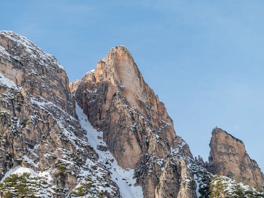 Schneebedeckte Felsgipfel ragen vor blauem Himmel auf