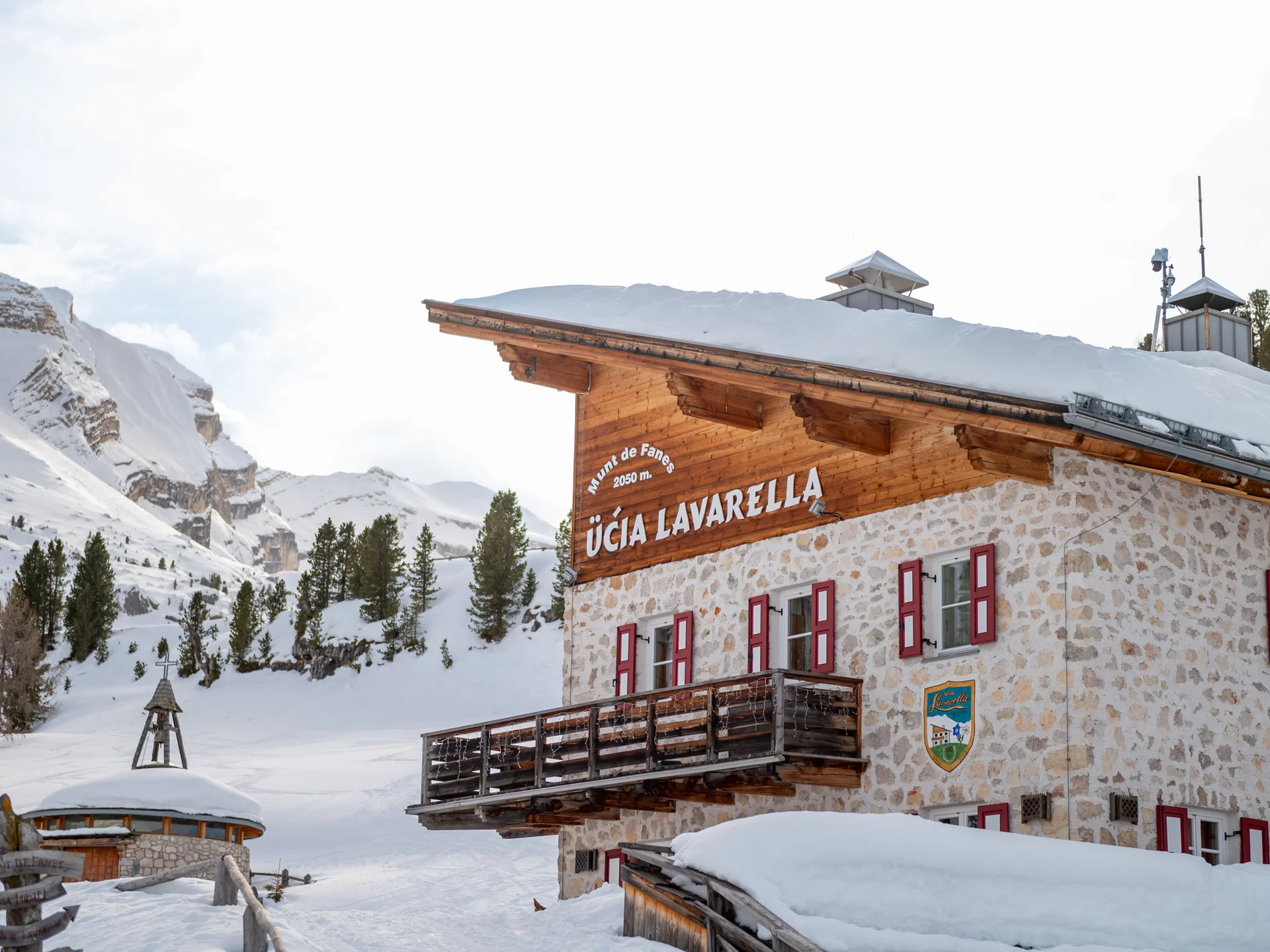 Naturparks Fanes-Sennes-Prags und Puez-Geisler | Chalet Löm Verschneite Berghütte Ücia Lavarella vor einer winterlichen Bergkulisse