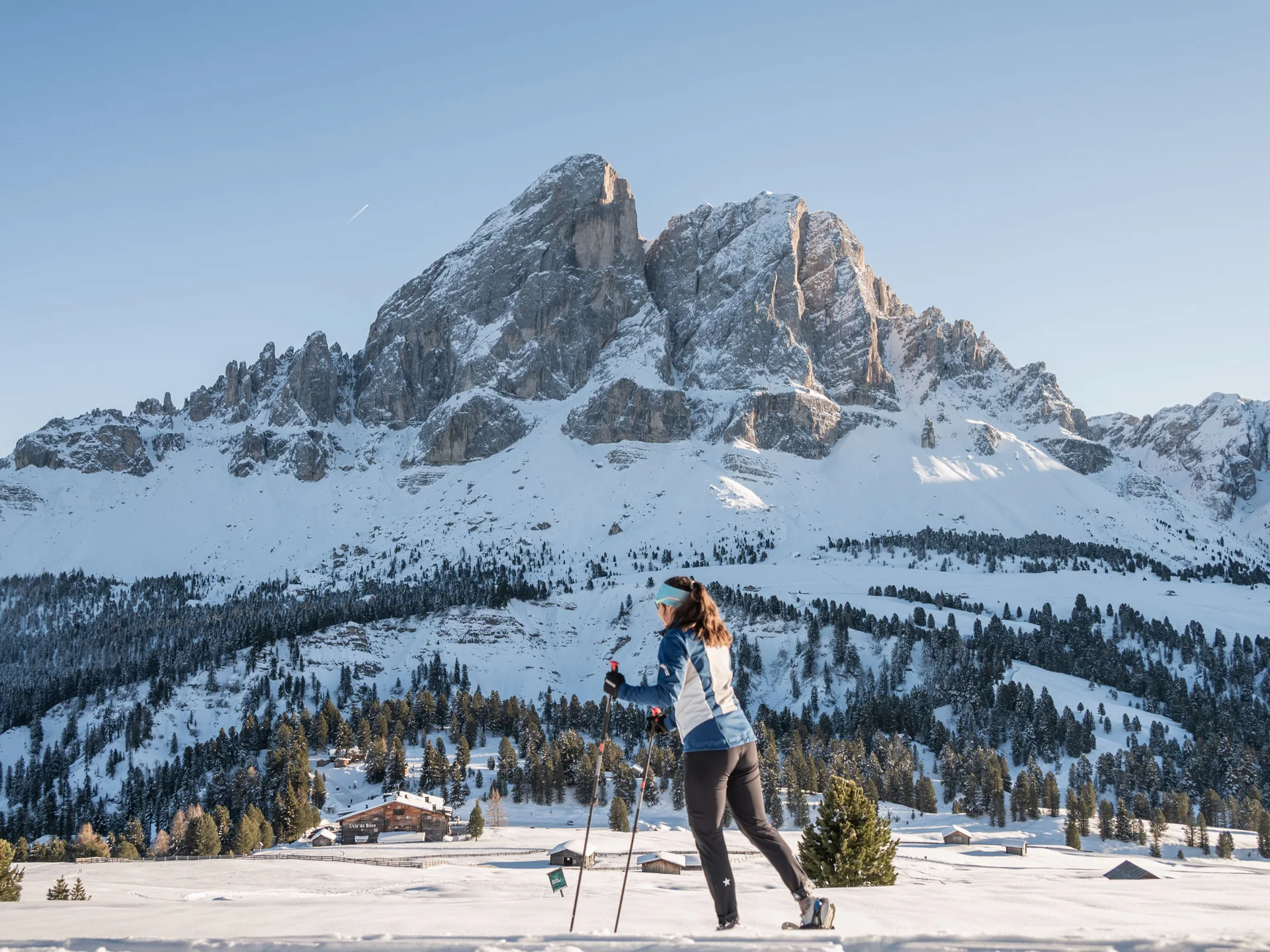 Langläuferin vor einer verschneiten Bergkulisse