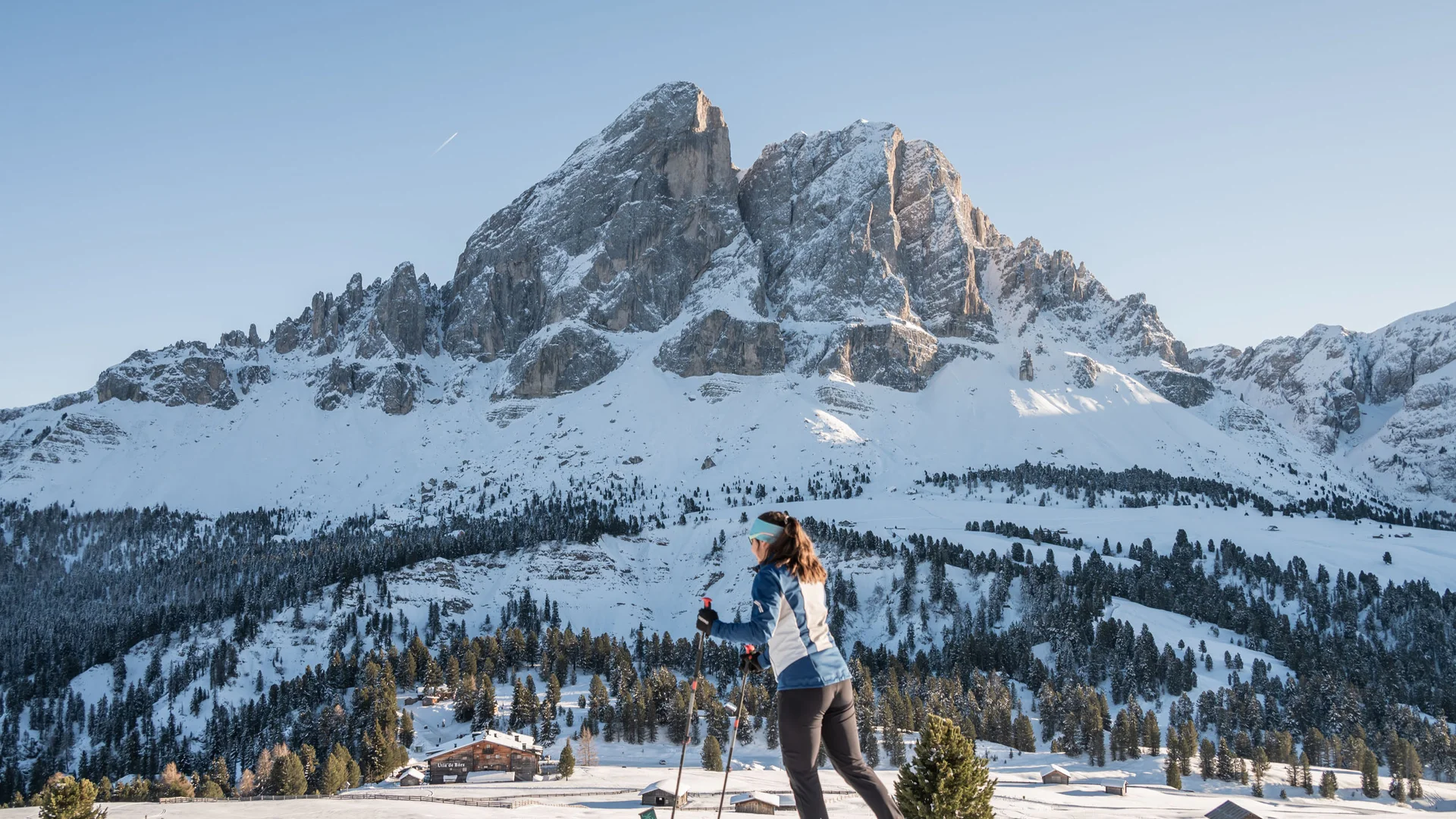 Langläuferin vor einer verschneiten Bergkulisse