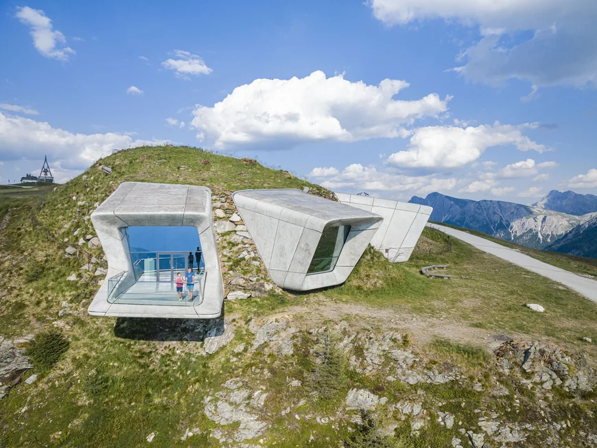 Naturparks Fanes-Sennes-Prags und Puez-Geisler | Chalet Löm Moderne Betonpavillons am Berghang mit zwei Personen und Bergpanorama